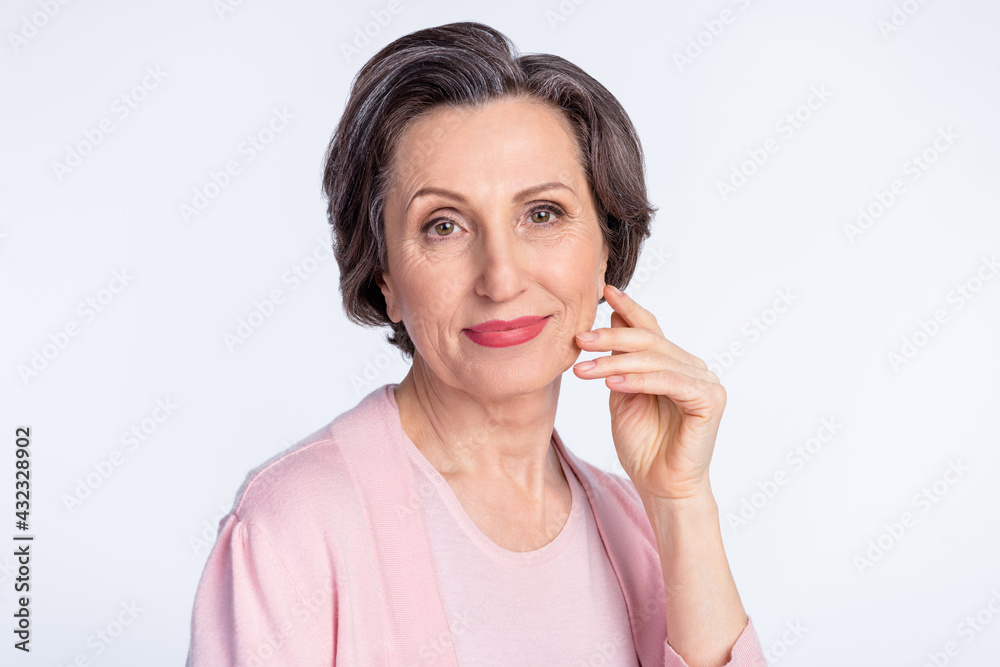 Photo of elderly attractive woman happy positive smile hand touch cheek isolated over grey color background Photo of elderly attractive woman happy positive smile hand touch cheek isolated over grey color background