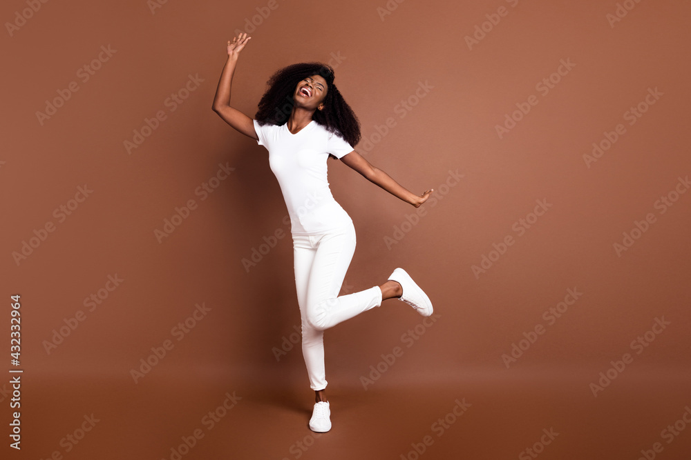 Full size photo of young excited black girl happy positive smile have fun dance isolated over brown color background