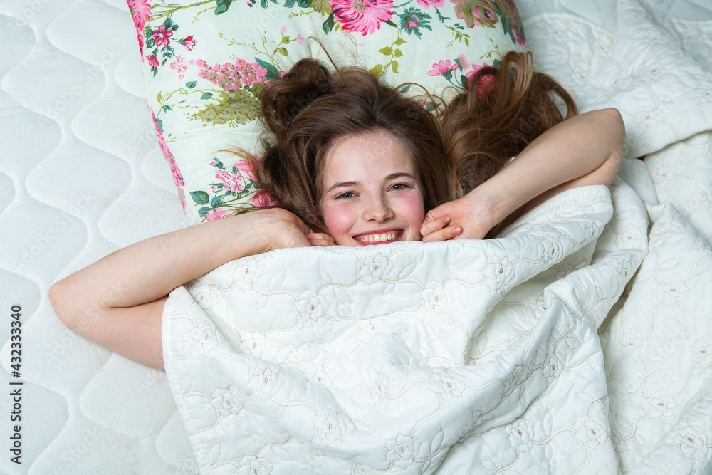 Happy girl waking up stretching arms on the bed in the morning. Beautiful young woman lying down in the bed and sleeping. white woman waking up Happy girl waking up stretching arms on the bed in the morning. Beautiful young woman lying down in the bed and sleeping. white woman waking up
