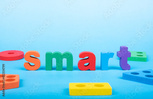 Smart word written with wooden alphabets blocks on blue chart kids children background