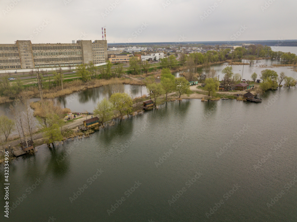 City lake shore in cloudy weather. Aerial drone view.