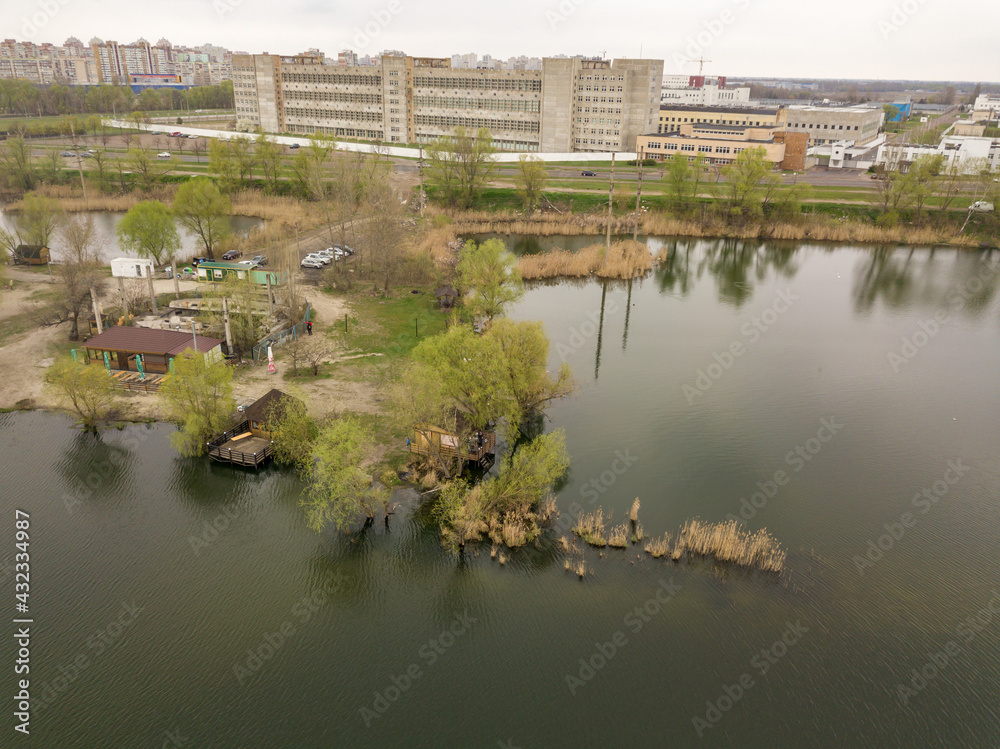 City lake shore in cloudy weather. Aerial drone view.