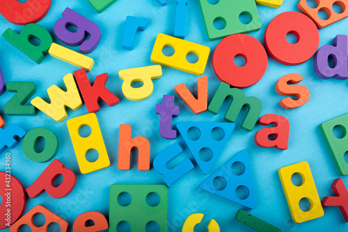 colorful wooden alphabets and geometric shapes on blue color chart kids children background