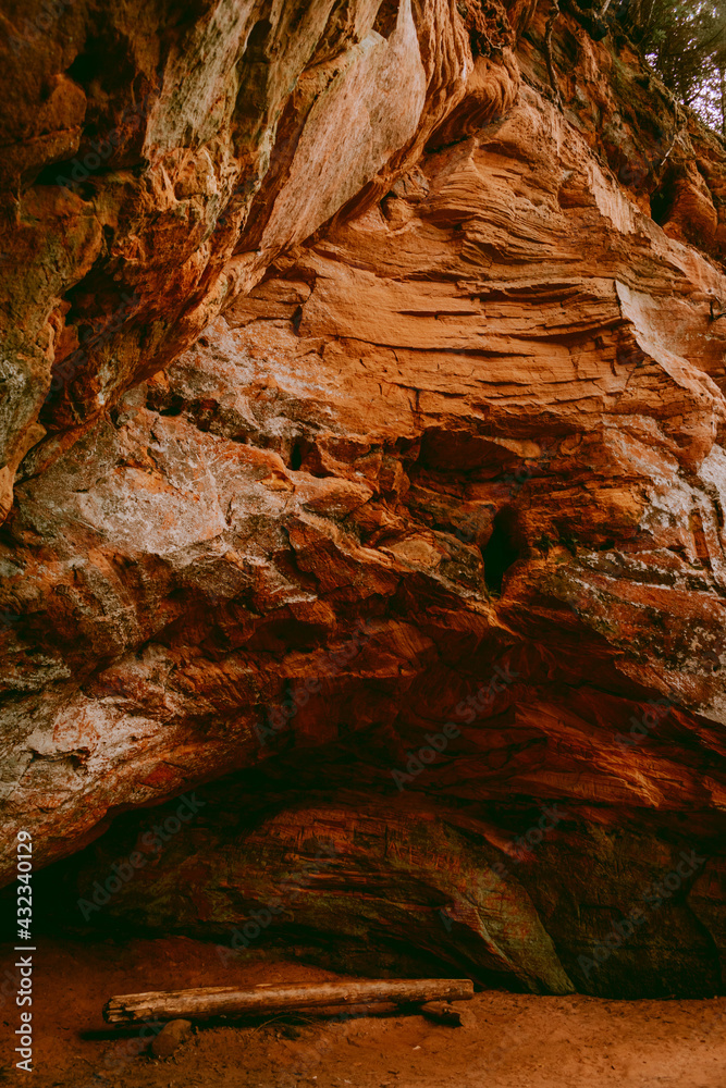 Beautiful red sandstone cliffs and cave of the Licu Langu sandstone massive near Gauja river in Latvia