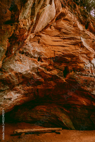 Beautiful red sandstone cliffs and cave of the Licu Langu sandstone massive near Gauja river in Latvia