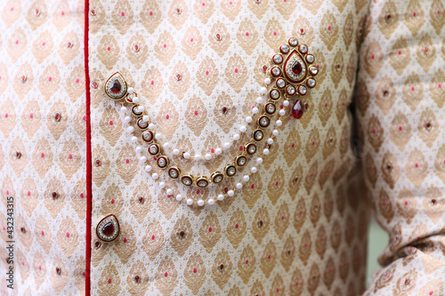 Fotografiet Closeup of a brooch on a Sherwan of an Indian groom during the wedding ceremony
