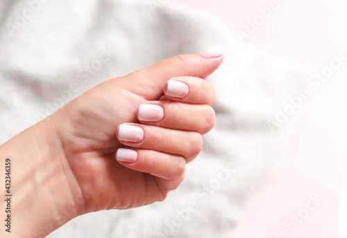 Gradient manicure and Hands Spa. Beautiful Woman hand closeup. Manicured nails and Soft hands skin. Beautiful woman's nails with beautiful baby boomer manicure, pink background. Copy space  photo