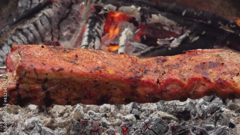 Close-up of the juicy spiced ribs on the skewers placed above the open fire Close-up of the juicy spiced ribs on the skewers placed above the open fire