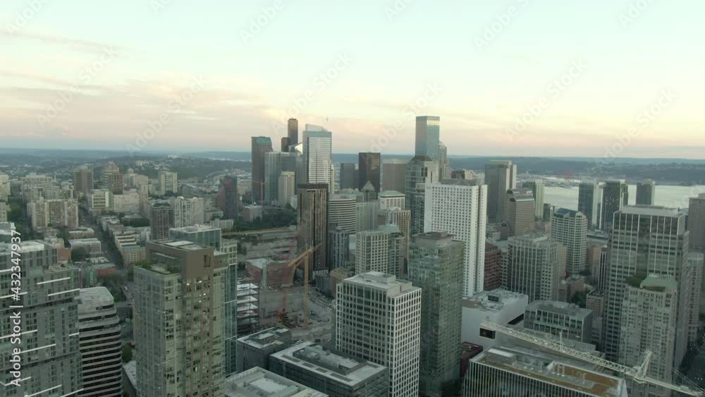 Aerial Shot Of Construction Site Amidst Modern Skyscrapers, Drone Flying Forward Over Cityscape By Elliot Bay Against Sky At Sunset - Seattle, Washington Aerial Shot Of Construction Site Amidst Modern Skyscrapers, Drone Flying Forward Over Cityscape By Elliot Bay Against Sky At Sunset - Seattle, Washington