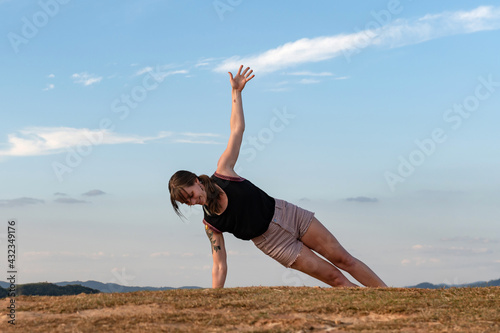 young woman exercising alone on summer with a big blue sky