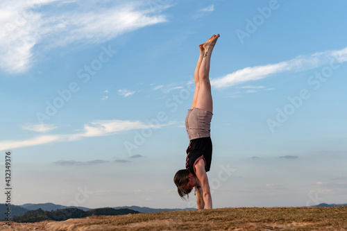 young woman exercising alone outdoor on summer with a big blue sky