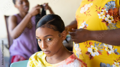 Young black girl getting hair braided