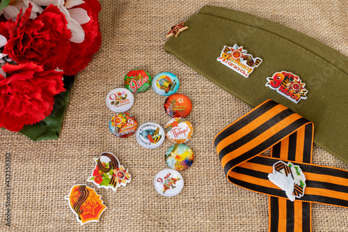 Concept background of May 9 russian holiday Victory Day. Red carnations, St. George's ribbon and order of the Red Star. Cabochons with the text in Russian: May 9, Victory, I remember, I am proud. On