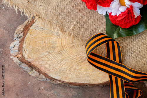 Concept background of May 9 russian holiday Victory Day. Red carnations, St. George's ribbon and order of the Red Star. On wooden background, copy space