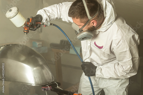 Fototapeta Naklejka Na Ścianę i Meble -  The painter paints the motorcycle tank with special nano wax