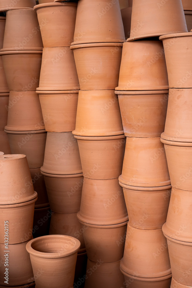 A pile of plant pots, Lots of orange flowerpots, Clay flower pots at the plant shop A pile of plant pots, Lots of orange flowerpots, Clay flower pots at the plant shop