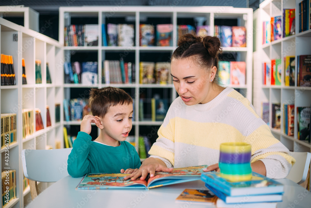 Mom and her little child, the preschooler son, read together children's books Mom and her little child, the preschooler son, read together children's books