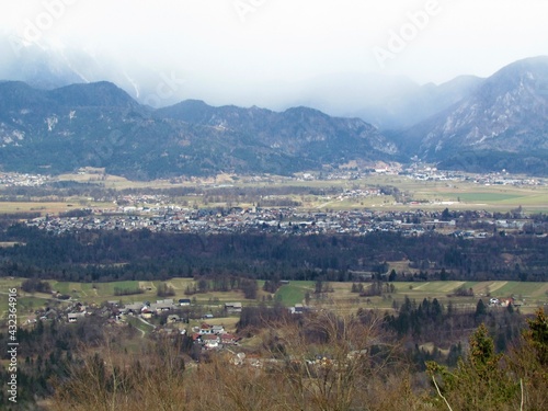 Aerial view of the town Lesce in Gorenjska, Slovenia surrounded by forest and fields and hills behind photo