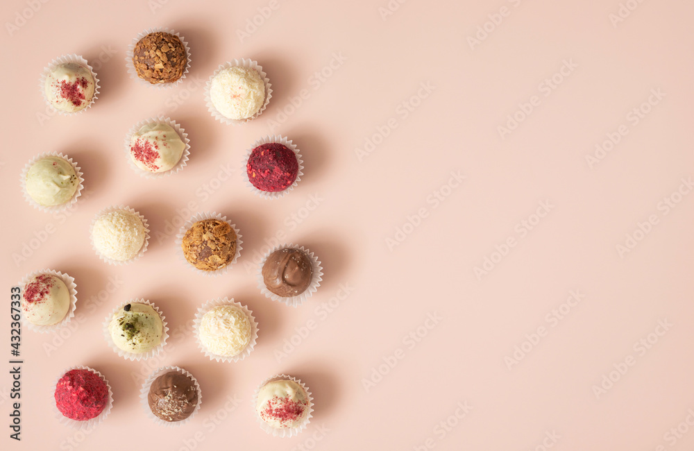 Assorted candies with chocolate, karkade, coconut and nuts on a pastel pink background. Truffles or energy balls. Copy space, top view Assorted candies with chocolate, karkade, coconut and nuts on a pastel pink background. Truffles or energy balls. Copy space, top view