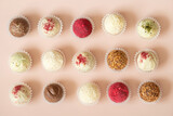 Assorted truffles on a pink background. Homemade raw energy balls, candies. Sweets background. Top view, flat lay.