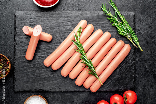 Raw sausages on stone background