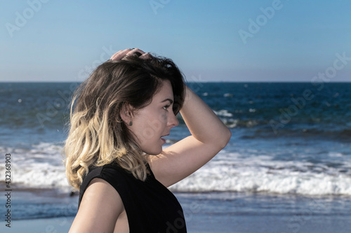 amazed woman to see something in the distance with a sea and a blue sky