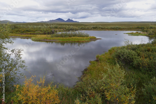 Permafrost lake in Yukon tundra, thermokarst lake, also called thaw depression, formed by thawing ice-rich permafrost, global warming climate change concept, Canada