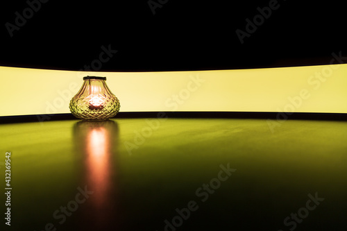 Glass candle holder with colourful yellow light painting