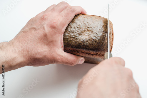 a man cuts bread, a piece of bread, a burnt crust of bread 