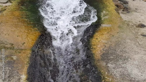 Clear stream of water runs down a concrete gutter.