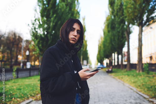 Pensive woman browsing mobile phone during walk © BullRun