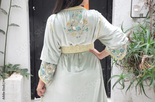 Moroccan model wears a Moroccan caftan. The caftan is a long, flowing type of robe-like dress that is often worn in Morocco. photo