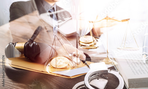 Justice and law concept.Male judge in a courtroom with the gavel  working with  computer and docking keyboard  eyeglasses  on table in morning light