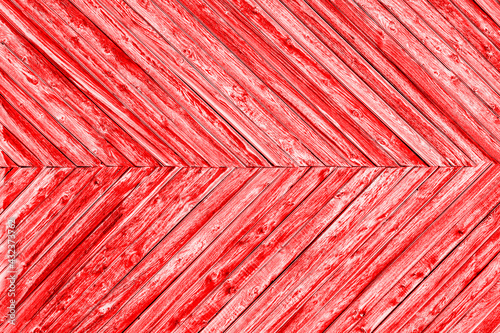 Red background is made of narrow wooden planks at an angle to each other.