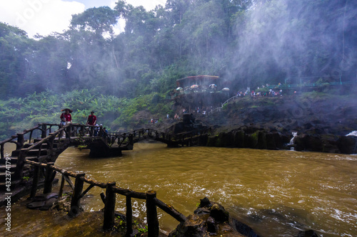Tourists watch tall waterfall in forest in Dambri, Bao Loc city, Vietnam photo