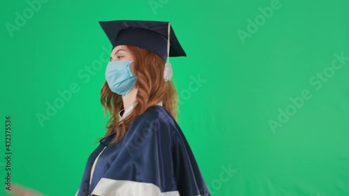 education online, female graduate in an academic gown and hat shows diploma disgustedly throws it and leaves green screen background, chroma key photo