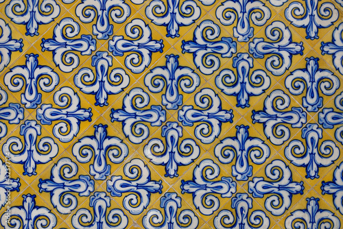 Beautiful ornament on ceramic vintage tiles in blue and yellow tones. Spanish style ceramic tiles