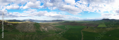 180 degree aerial photo of Ogliastro lake in the heart of Sicily with Etna view. Place of great naturalistic value surrounded by hills planted with cereals. A destination for migratory bird species.