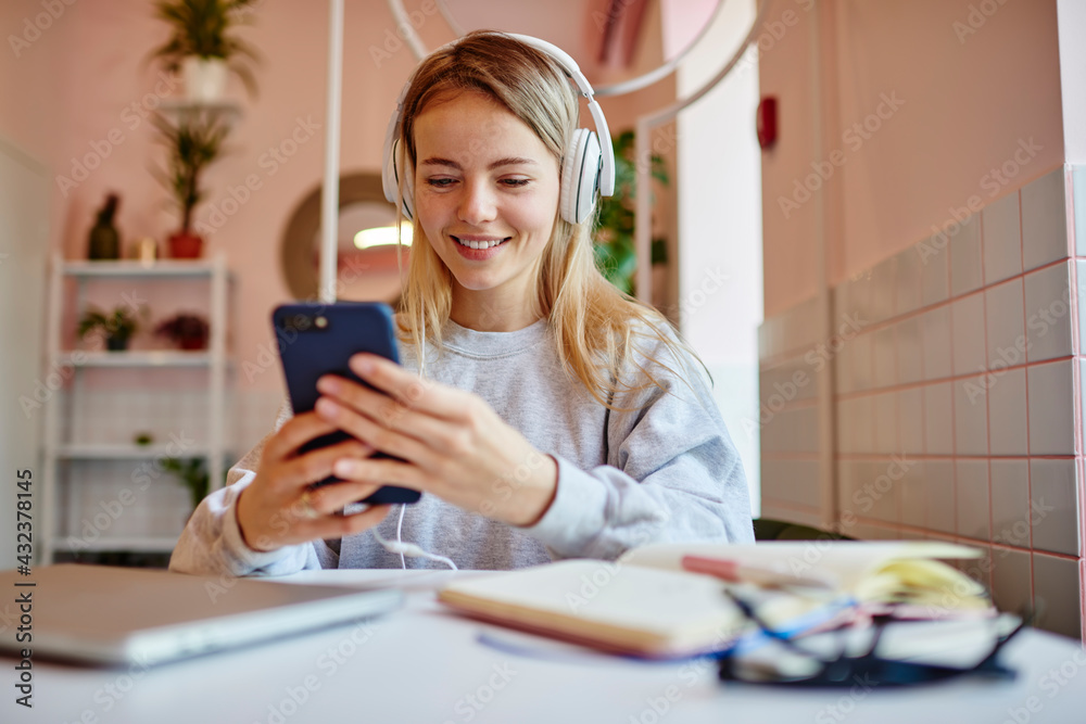 Happy Caucasian blogger in electronic headphones for noise cancellation choosing music podcast on modern smartphone device, cheerful hipster girl in earphones listening positive audio records Happy Caucasian blogger in electronic headphones for noise cancellation choosing music podcast on modern smartphone device, cheerful hipster girl in earphones listening positive audio records