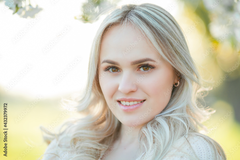 Beautiful young woman is resting on a picnic in a blooming garden. White flowers. Spring. Happiness. Beautiful young woman is resting on a picnic in a blooming garden. White flowers. Spring. Happiness.