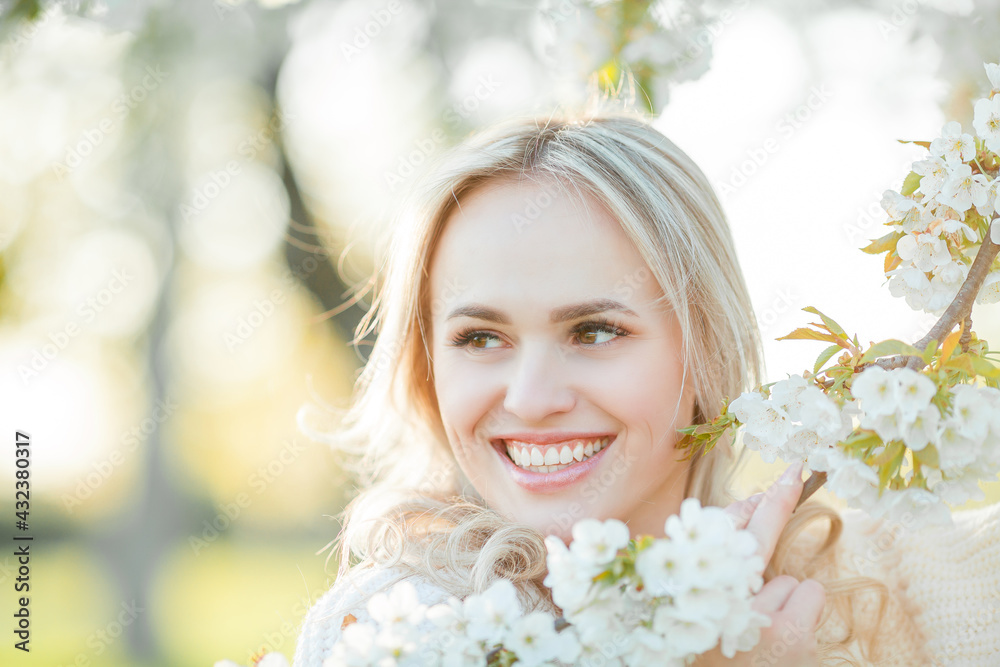 Beautiful young woman is resting on a picnic in a blooming garden. White flowers. Spring. Happiness. Beautiful young woman is resting on a picnic in a blooming garden. White flowers. Spring. Happiness.