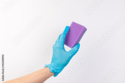 Sponge for washing dishes in female hand. Hand in a latex glove. Woman's hand gesture or sign isolated on white. A hand in a glove holds a sponge for washing and cleaning dishes