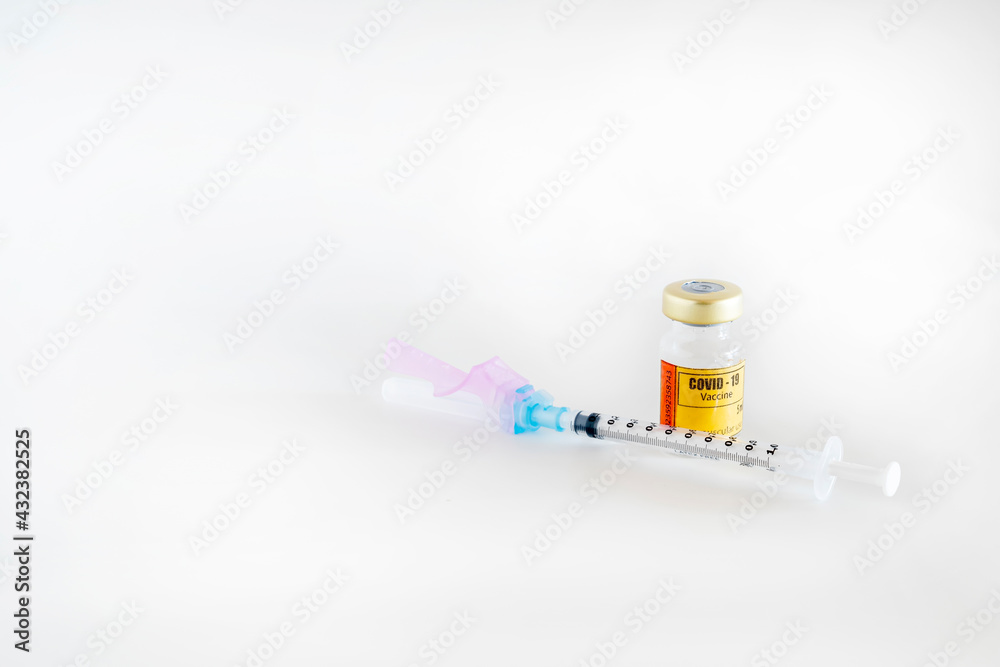Glass vial for intramuscular injection containing the vaccine for covid-19 with syringe and needle on white background. Glass vial for intramuscular injection containing the vaccine for covid-19 with syringe and needle on white background.