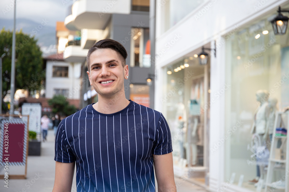 Obraz premium Portrait of young handsome man of Arabic ethnicity on the city streets. Iranian guy over with hipster hairstyle wearing casual attire. Close up, copy space for text.