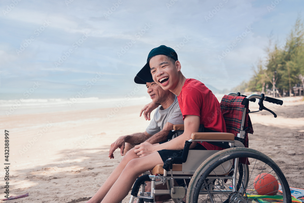 Asian special child on wheelchair on the beach with parents in family holiday to travel, exercise and learning about nature around the sea beach, Life in the education age, Happy disabled kid concept.