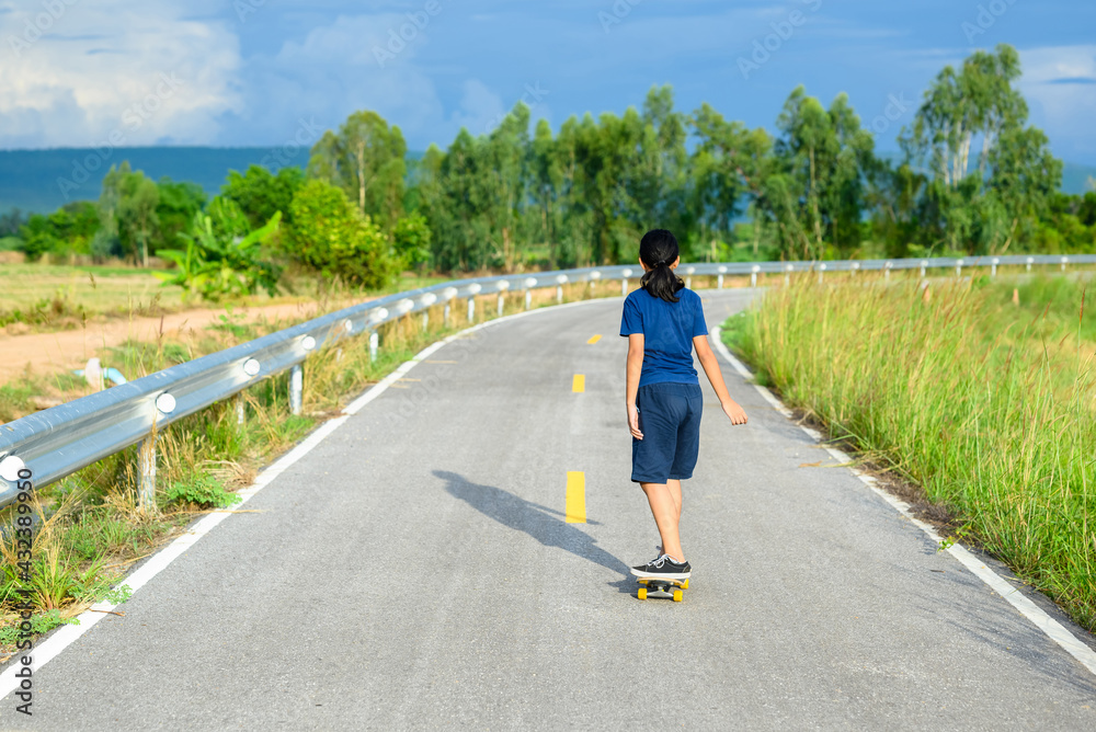 Fototapeta premium Child Play Skateboard on the Countryside Road