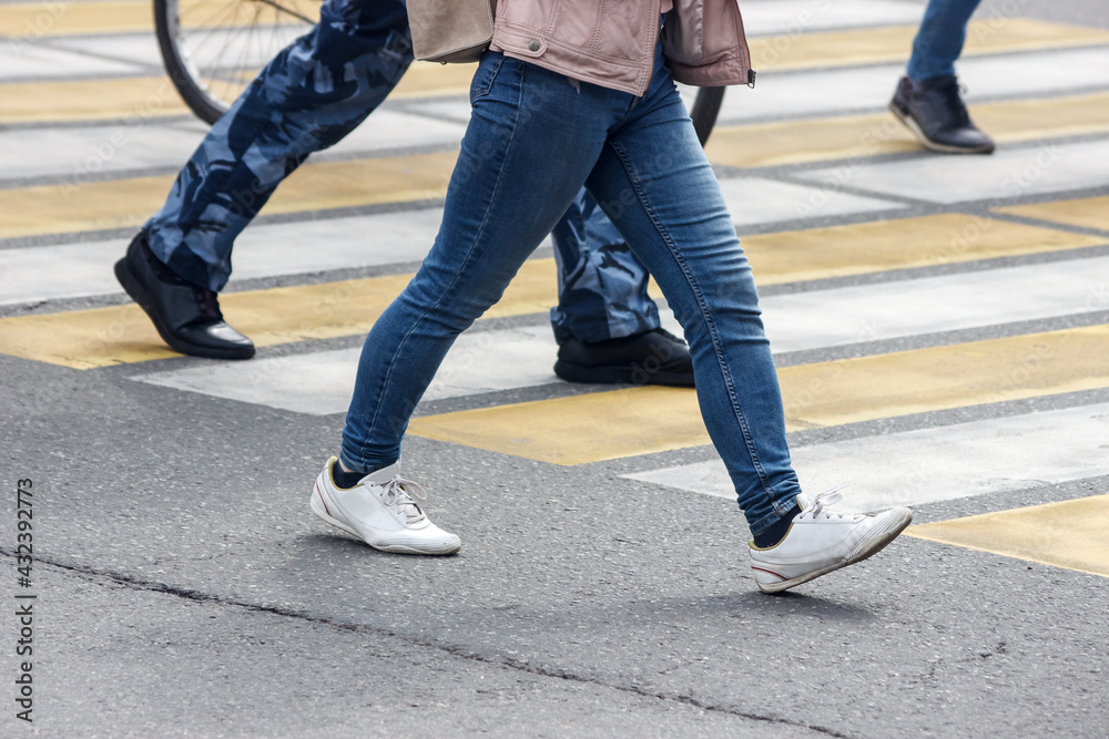 pedestrians cross the street at a pedestrian crossing