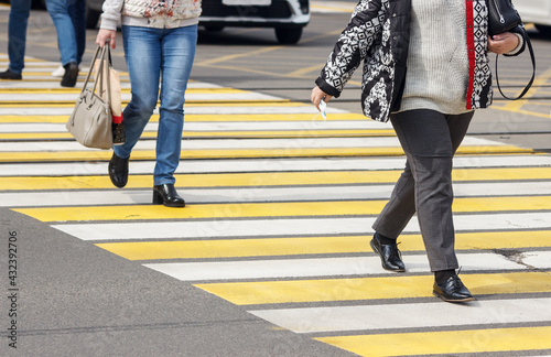 pedestrians cross the street at a pedestrian crossing