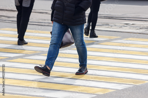 pedestrians cross the street at a pedestrian crossing