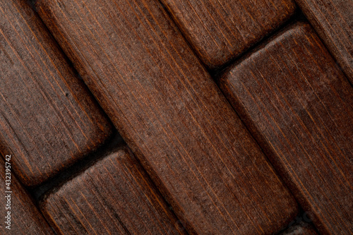 Dark wood texture in the shape of small rectangles (collection of natural and vegetal fibers). Foreground.